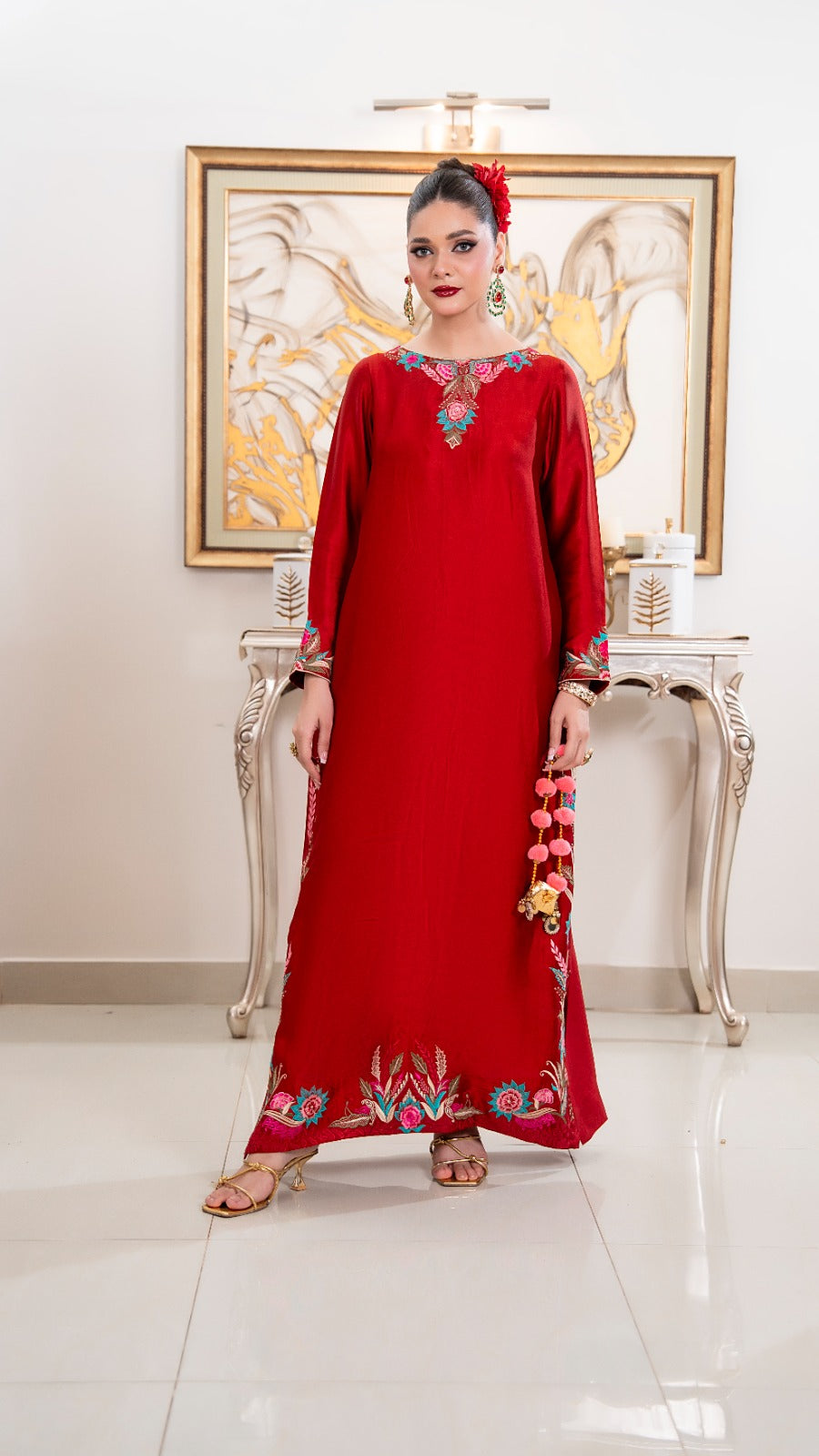 Shop Red Orchid by FAMA by Sana Sarah's, a stunning floor-length crimson silk tunic featuring turquoise and pink floral embroidery, side slit borders, and festive tassel details.